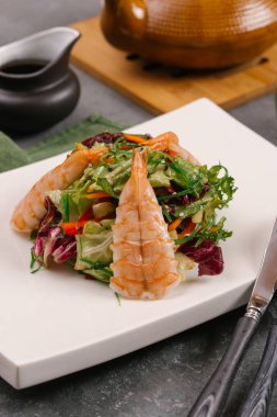 Tay yeşil beyaz tabak, sebze ve gri bir tablo lahanası salatası