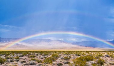 Güzel gökkuşağının üstünde bir Amerikan çöl tepeler ve dağlar arka plan ve boşaltmak için açık mavi gökyüzü ile