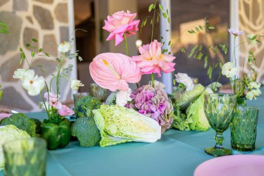 Renkli Çiçekler ve Lezzetli Yemek Deneyimi İçin Taze Sebzeler içeren Canlı Masa Düzenlemesi