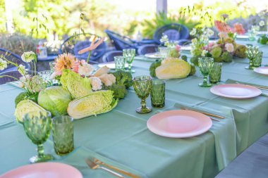 Taze sebzeler ve çiçek aranjmanları sunan güzel bir masa, canlı bir bahçe partisi ya da açık hava ortamında özel toplantı için mükemmel.