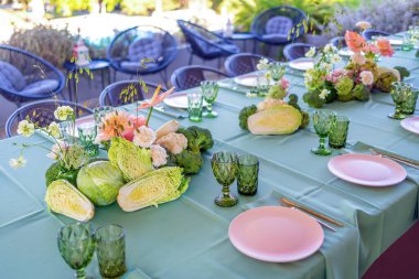 Taze sebzeler ve Büyüleyici Açık Hava Yemek Deneyimi için Çiçek Düzenlemeleri içeren Zarif Masa Ayarları