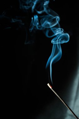 Bir aromatik sopa ışık ışınları içinde gelen siyah arka plan üzerine izole Soyut Mavi duman