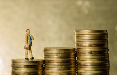 altın sikke yığın yığını üzerine yürüyen minyatür resim iş adam. iş başarı kavramı