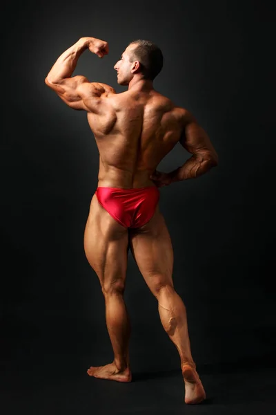 Studioaufnahme Eines Jungen Männlichen Bodybuilders Der Auf Schwarzem Hintergrund Posiert — Stockfoto