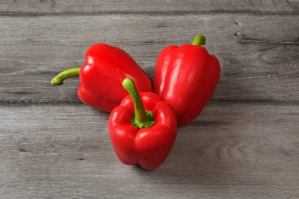 Bovenaanzicht Van Het Tabel Drie Rode Paprika Een Grijze Houten — Stockfoto