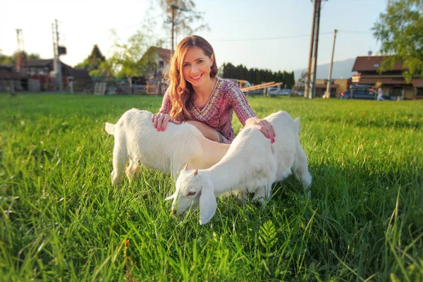 Dvě Malé Kozí Děti Zelené Louce Rozmazané Mladá Žena Pozadí — Stock fotografie