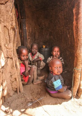 Amboselli park, Kenya - 02 Nisan 2015 yakınlarında bilinmeyen Masai köy: grup zavallı kirli çocuk yüzleri ve ağız ile kaplı onların kulübe girişinde oturan sinekler ile.