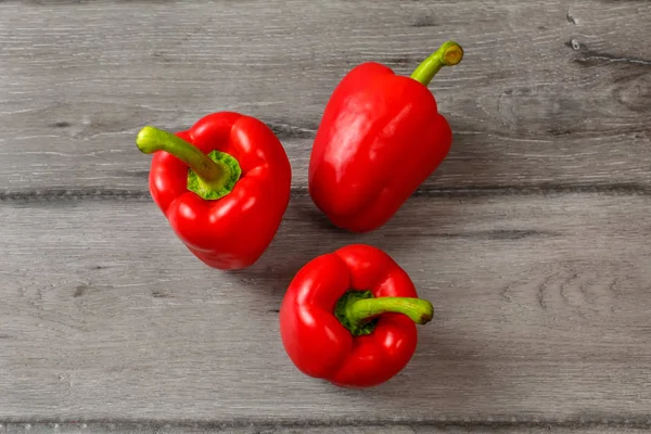 Table Top View Three Red Bell Peppers Gray Wood Desk — Stock Photo, Image