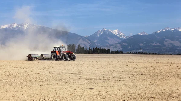 Traktor Húzza Fém Görgők Száraz Területen Hegyek Háttérben Tavaszi Talaj — Stock Fotó