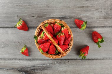 Tablo üstten görünüm - çilek, sepetle bazı gri ahşap masanın üzerine döktüm.