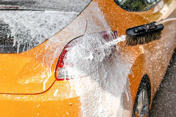 Yellow Car Washed Carwash Soap Foam Spraying Drops Sun Lit — Stock Photo, Image