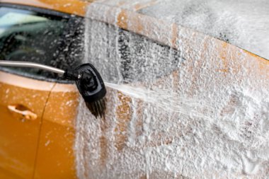 Şampuan ve sarı araba tarafında, cennet temizlenmiş püskürtme köpük.