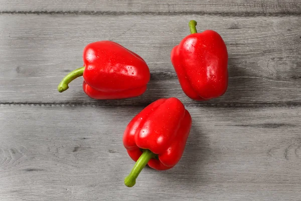 Tischansicht Drei Rote Paprika Auf Rustikalem Grauem Holztisch — Stockfoto