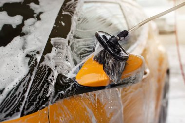 Self servis carwash yan ayna bir araba temizlenir.