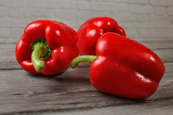 Three Bright Red Bell Peppers Wooden Desk Focus Water Drops — Stock Photo, Image