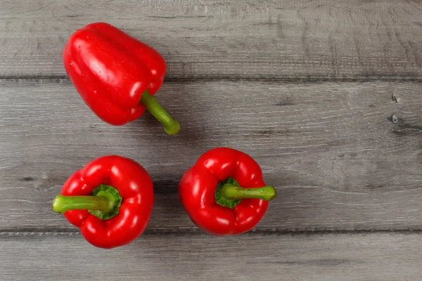 Tabletop View Three Red Bell Peppers Gray Wood Desk — Stock Photo, Image