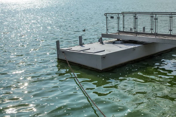 Metal tekne rıhtımda bir yeşil su Gölü, küçük dalgalar üzerinde kıyıya lider zinciri pırıl pırıl güneş. Brno, Çek Cumhuriyeti