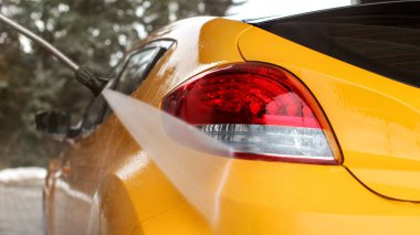 Sarı araba geri öz yıkanmış hizmet carwash, su akımını arka ışık püskürtme