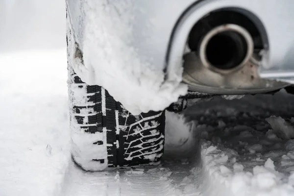 Detail pneumatiky auto a výfuk na zimní sníh — Stock fotografie