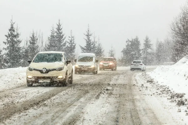 Certovica, Slovaquie - 08 juin 2019 : Voitures conduisant sur une route forestière enneigée glissante pendant le blizzard hivernal. Les conditions de conduite deviennent dangereuses causant un trafic lent, souvent à cette période de l'année — Photo