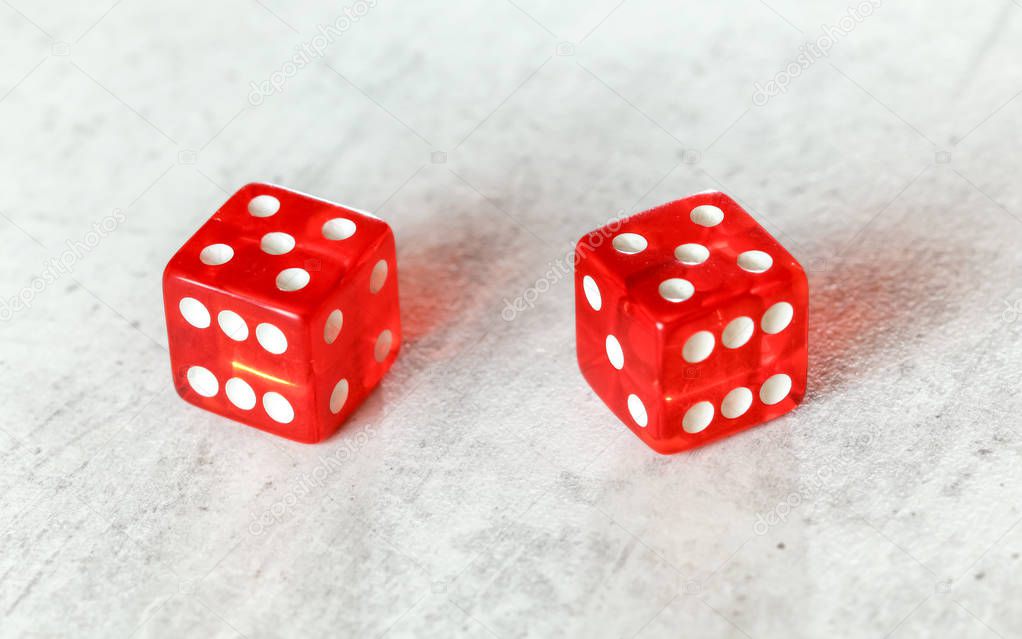 Two translucent red craps dices on white board showing Hard Ten number 5 twice 