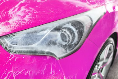 Ön far pembe araba yıkanmış self servis carwash, su püskürtme yaprakları beyaz köpük cam