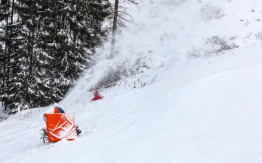 Yapay kar kayak piste üzerinde buz kristalleri püskürtme topu yapma, arka planda ağaçlar