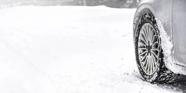 Détail du pneu d'hiver de la voiture route enneigée, large bannière, espace vide pour le texte à gauche. toutes les marques de logos sur pneus retirés — Photo