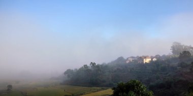 Pirinç tarlaları üzerinde Sabah sis, güneş küçük kil binalar alabiliyorum - Madagaskar Alakamisy bölgesinde tipik manzara