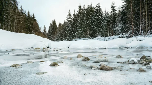 Το πρωί σε ένα παγωμένο δάσος ποταμού, πλήρως καλυμμένο με πάγο και χιόνι, μόνο μικρές κηλίδες του νερού που ρέει ορατό. — Φωτογραφία Αρχείου