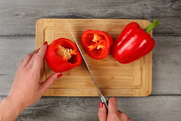 Tabletop view, woman hands cutting red bell pepper with chefs kn — Stock Photo, Image