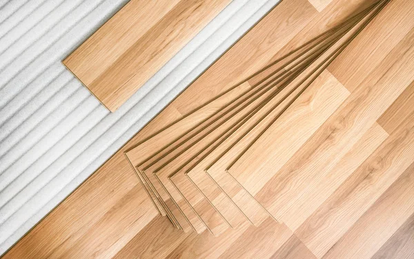 Azulejos de piso laminado con efecto de madera que pone sobre la base de espuma blanca, listo para ser instalado, vista de arriba hacia abajo - foto de fondo mejora del hogar — Foto de Stock