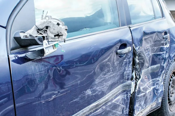 Voiture écrasée, détail sur le rétroviseur latéral et la porte - plaques métalliques déformées après un accident . — Photo