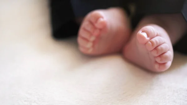 Infant baby boy legs in small black trousers, soft focus photo with detail on his feet, space for text down left corner — Stock Photo, Image