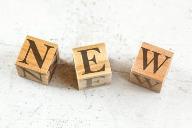 Beyaz tahta üzerinde kelime yeni üç ahşap küpler.