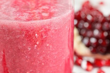 Cam pembe nar Smoothie içecek, arka planda bulanıklaştırılmış yarıya meyve