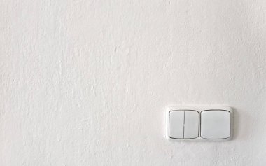 Beyaz duvarda eski ışık anahtarları taze boyanmış, plastik üzerinde boya bazı damla