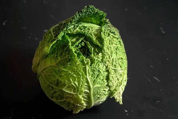 Closeup of savoy cole cabbage on black desk with marble effect. — Stock Photo, Image