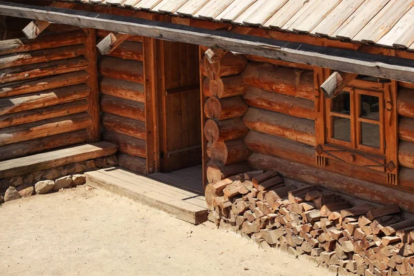 Wooden log cabin, lit by sun, detail on entrance door.