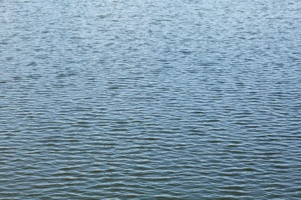 Superfície do lago, água quase calma apenas pequenas ondas. Água abstracta — Fotografia de Stock