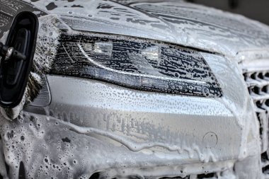 El araba yıkama yıkanmış gümüş araba ön ışık, fırça leavin