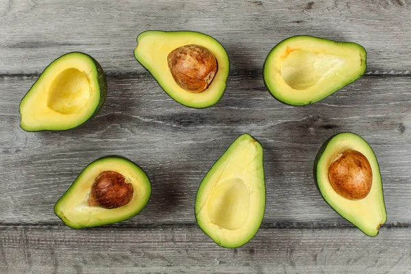 Vista de la mesa - mitades de aguacate dispuestos, algunos de ellos con el s —  Fotos de Stock