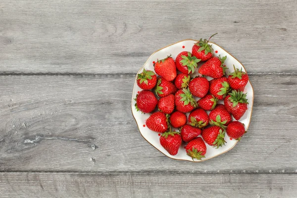 Vista de la mesa, plato con fresas en escritorio de madera gris. Espacio — Foto de Stock