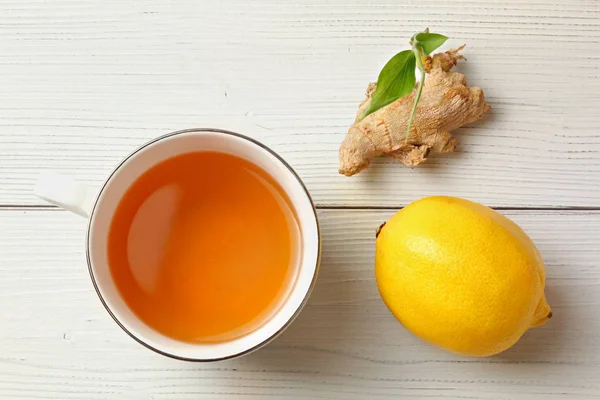 Tabletop view, porcelain cup of freshly brewed tea, dry ginger r — Stock Photo, Image