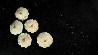 Tahta gibi koyu mermer beş beyaz pattypan squash kafaları, metin sağ tarafı için alan ile geniş afiş