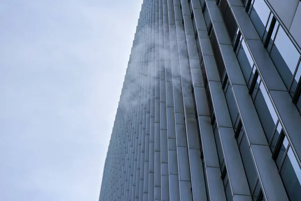 Steam from air conditioning heating coming out from modern steel and glass building, clear sky in background — Stock Photo, Image