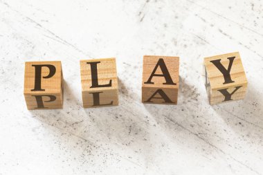 Beyaz çalışma tahtası üzerinde kelime Oyna ile dört ahşap küpler.