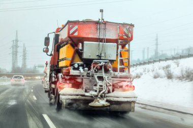 Parlak turuncu kum bakım kamyon karayolu üzerinde tuz ve kum deicing yayılan, arkasında sürüş arabadan görünümü