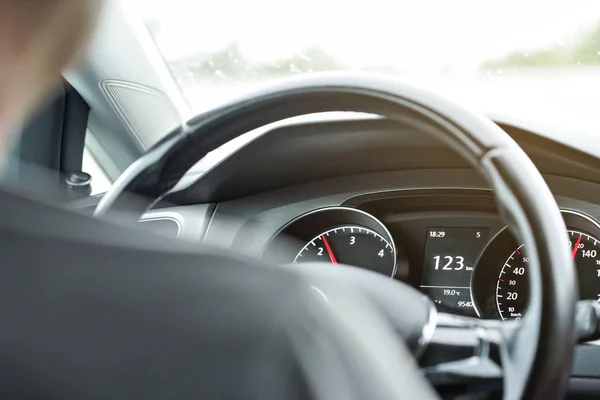 Man rijdt op een auto, uitzicht vanaf achterbank, detail op dashboard en stuurwiel — Stockfoto