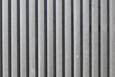 Metal levha çiti, güneş yandan parlıyor. Soyut yapı 